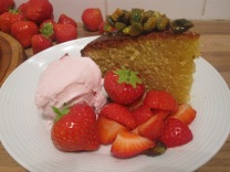 greek style honey and pistachio cake with strawberries and ice cream